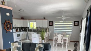 A modern living room with grey sofas and a kitchen in the background. - Key Largo Getaway (Key Largo)