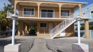 A two-story building with a balcony, a staircase, and a driveway. - Key Largo Getaway (Key Largo)