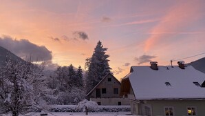 A snow-covered landscape with houses and a mountain in the background.