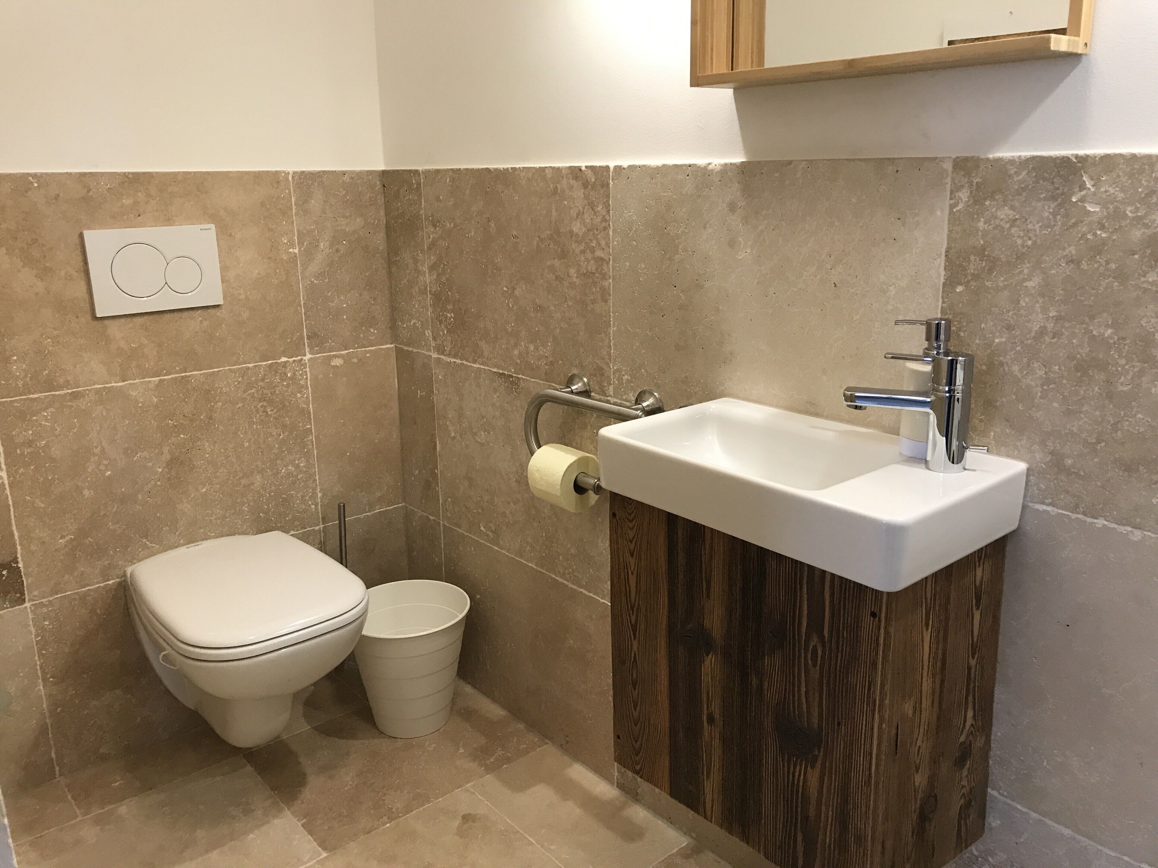 Une salle de bain avec des toilettes, un lavabo et un meuble en bois.