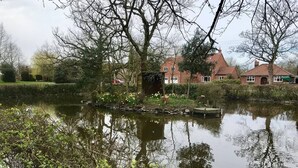 A pond surrounded by trees and houses with red roofs. - Woodlands Cottage - Rural Retreat - Near York (North Duffield)