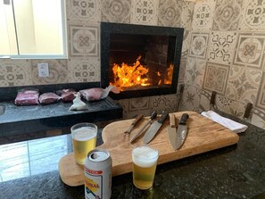 Eine Küche mit Kamin, einem Schneidebrett mit Messern, einer Bierdose und zwei Biergläsern.