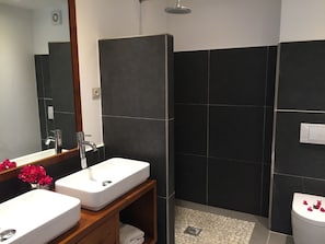 Un baño moderno con dos lavamanos, una ducha y un inodoro.