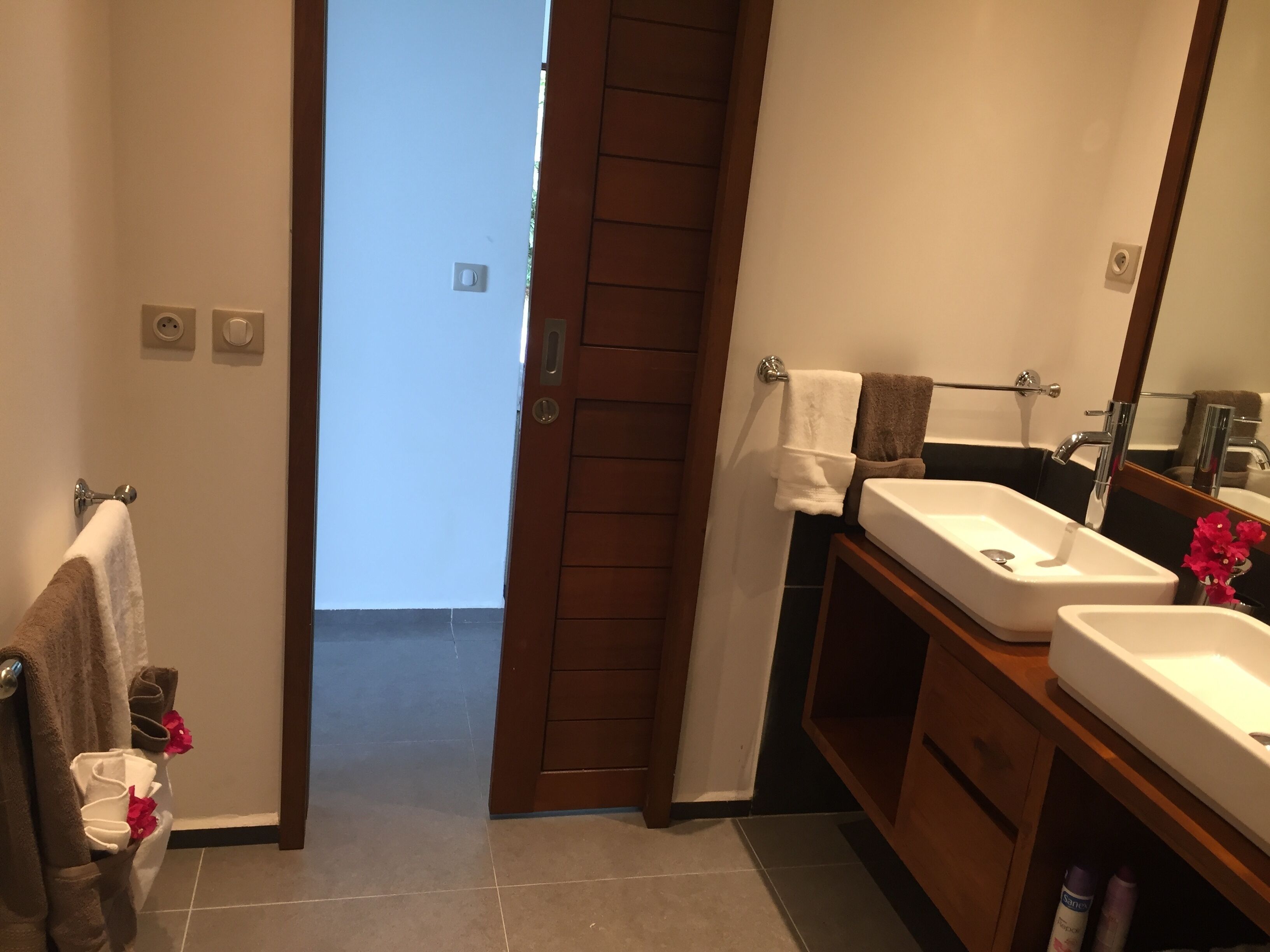 Un baño con dos lavamanos, un espejo y un perchero para toallas.