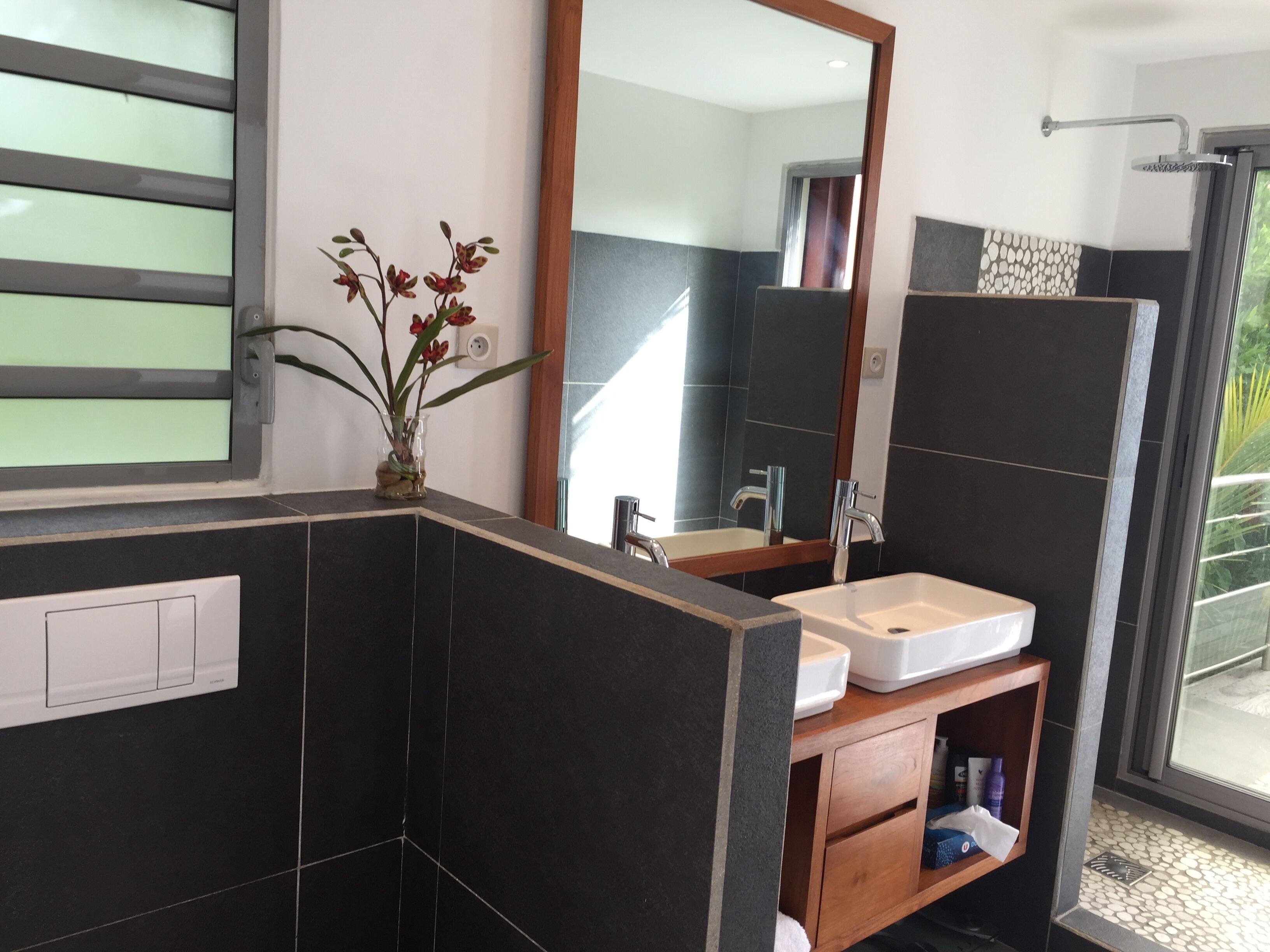 Een moderne badkamer met een grote spiegel, een wastafel en een douche.