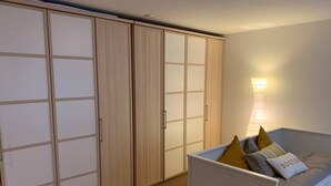 Ein Schlafzimmer mit einem Bett, einem Nachttisch, einer Lampe und einem Kleiderschrank.