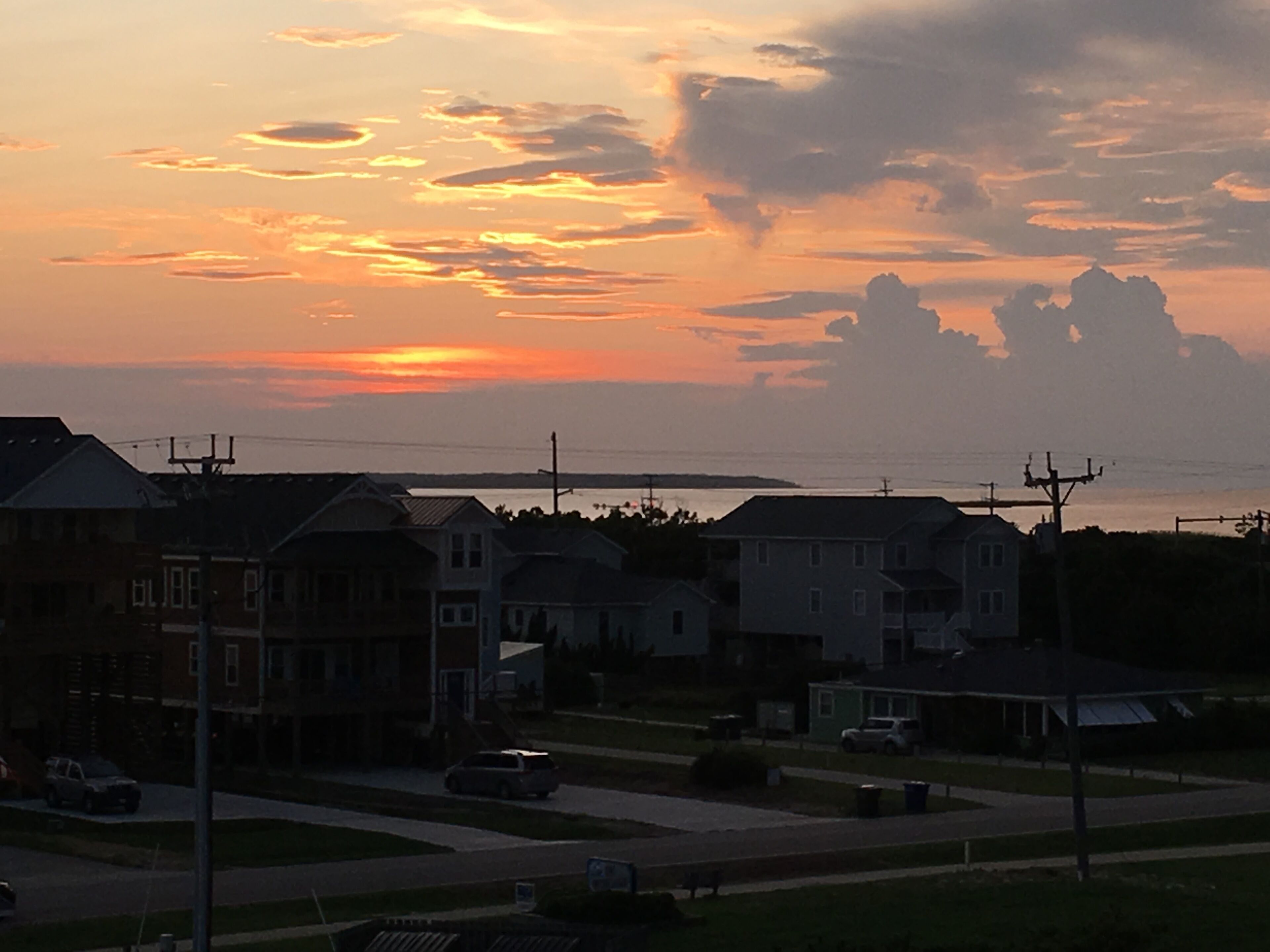 Un quartier résidentiel avec des maisons et une route, au coucher du soleil.