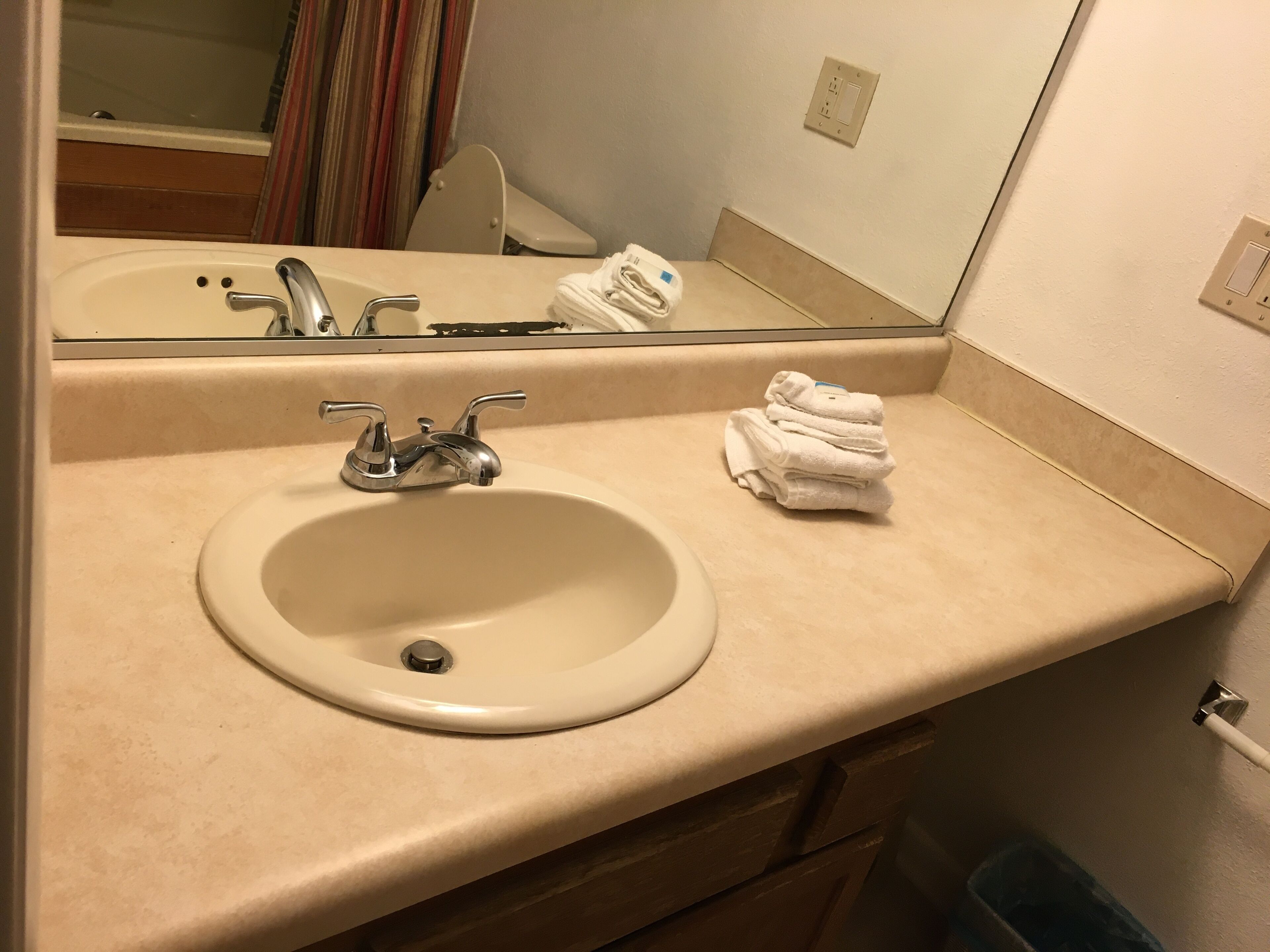 Une salle de bain avec un lavabo, un miroir et des serviettes.