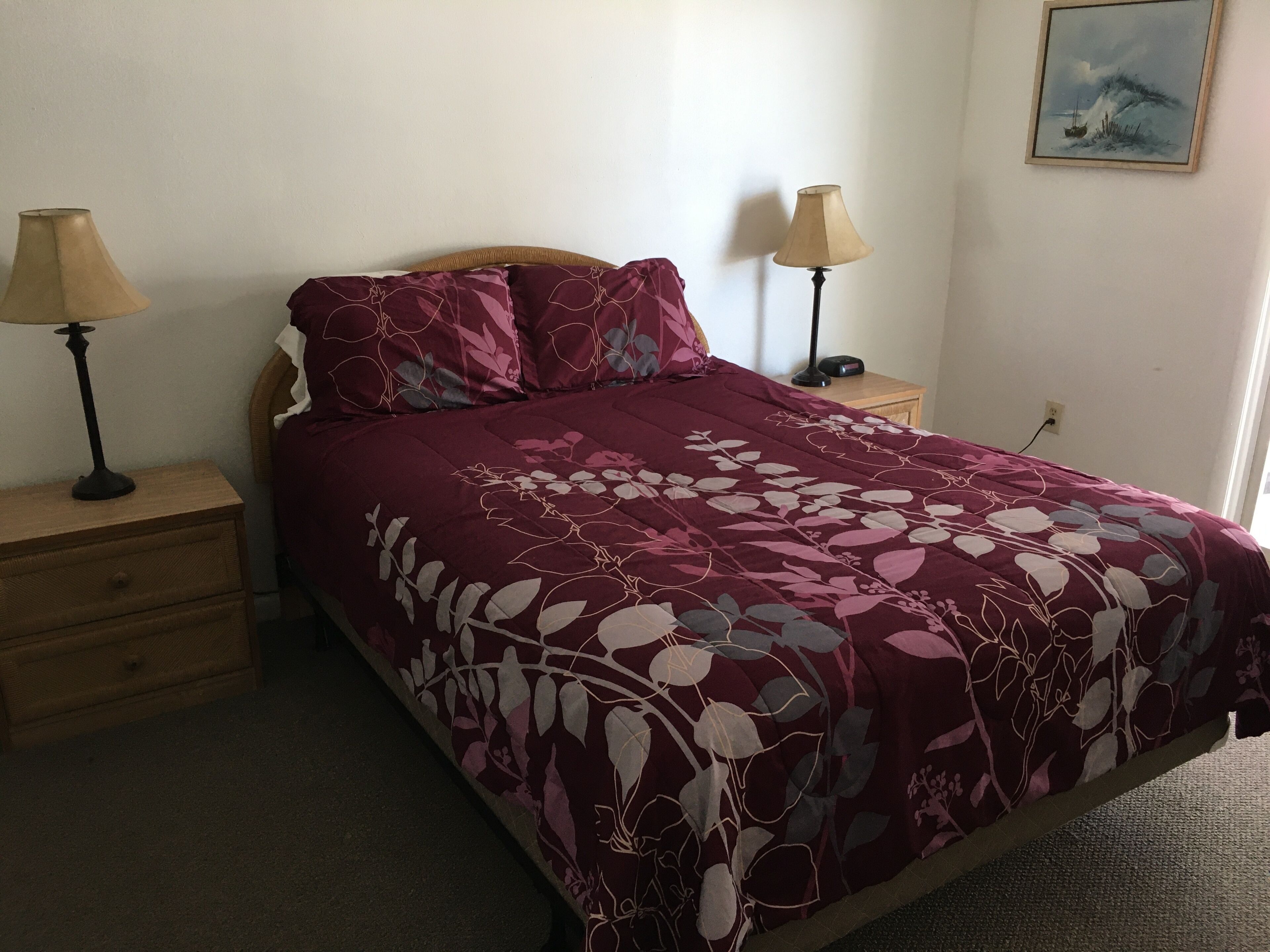A bedroom with a bed, two bedside tables, and a nightstand.