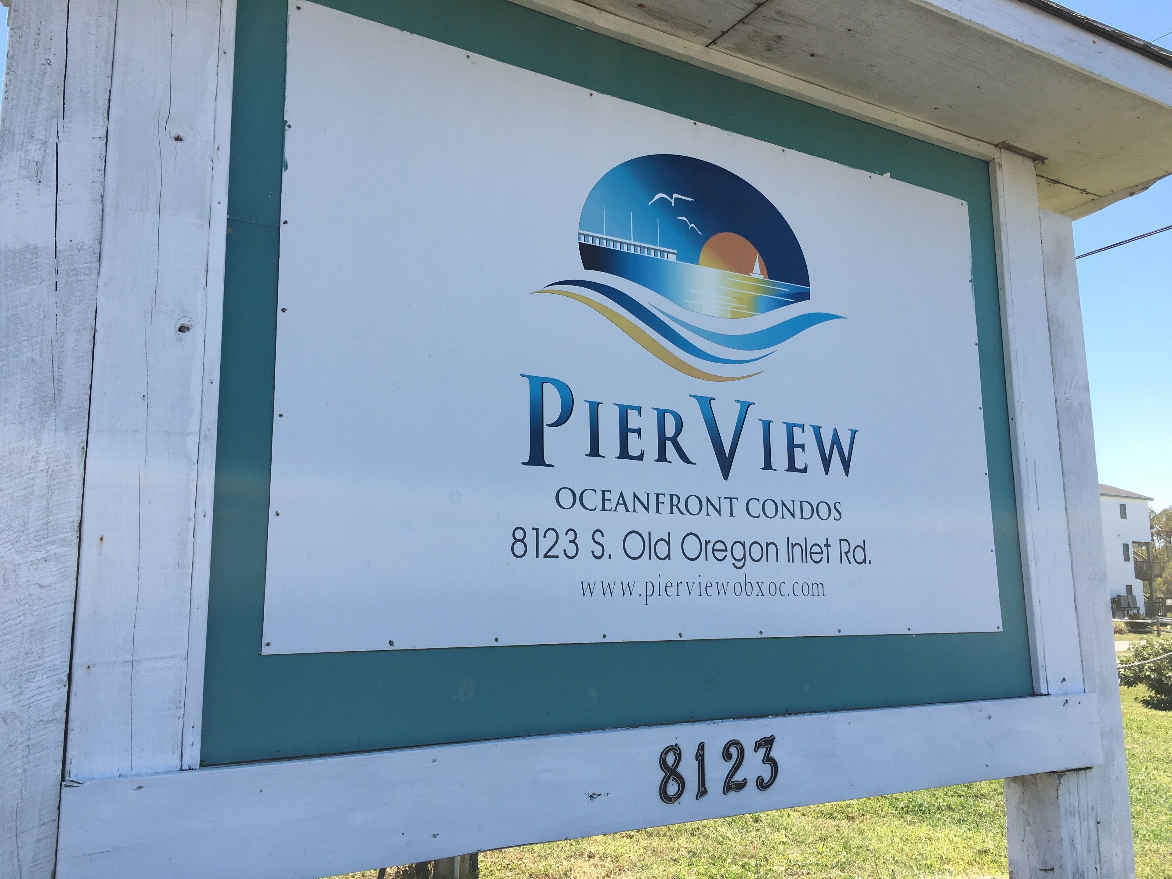 A sign for PierView Oceanfront Condos with a contact number and website.