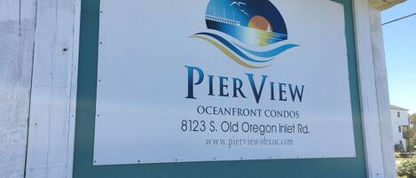 A sign for PierView Oceanfront Condos with a contact number and website.