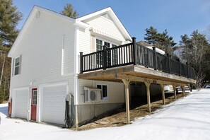 A two-story house with a covered deck and a garage.