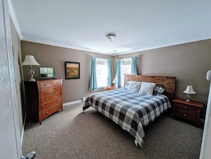 A bedroom with a bed, dresser, nightstand, and a window with curtains. - Woodland House w/ Deck, Near Beaches & Acadia (Hancock)