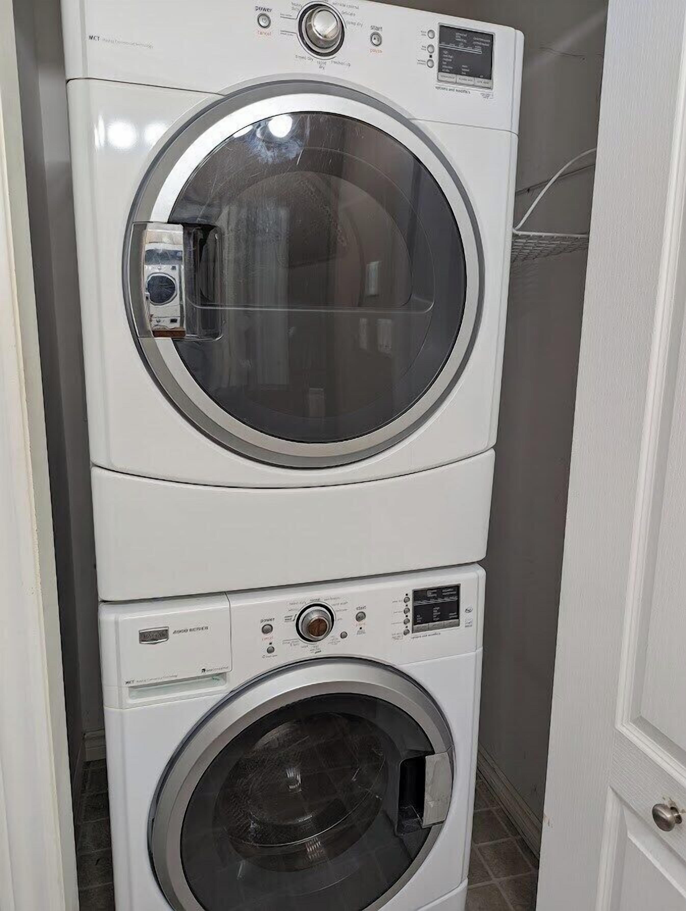 Een gestapelde wasmachine en droger in een wasruimte.