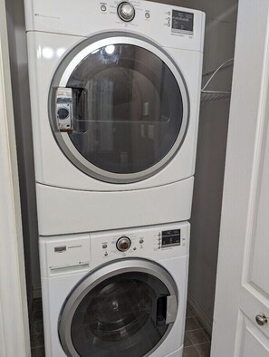 A stacked washer and dryer unit in a laundry room.