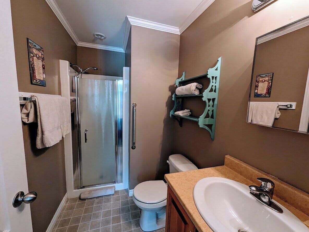 A bathroom with a shower, toilet, and sink.