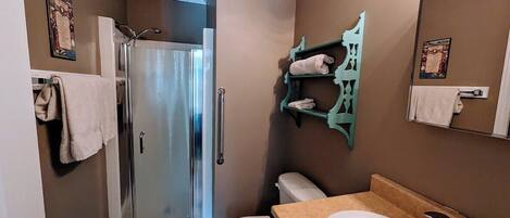A bathroom with a shower, toilet, and sink.