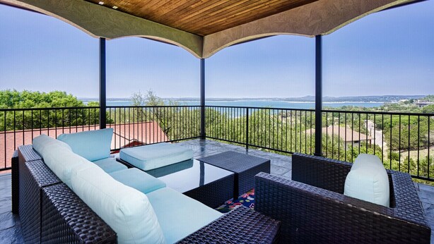 A covered outdoor seating area with a view of the sea and greenery. - Lakeview villa- spacious Mediterranean home with amazing lake views! (Canyon Lake)