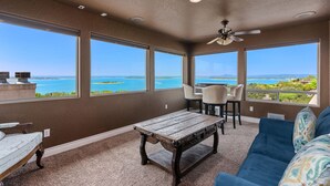 A room with a view of the ocean, a ceiling fan, and a table with chairs. - Lakeview villa- spacious Mediterranean home with amazing lake views! (Canyon Lake)