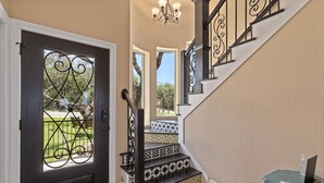 A staircase with black railings and patterned tiles, leading to an upper floor. - Lakeview villa- spacious Mediterranean home with amazing lake views! (Canyon Lake)