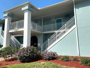 A two-story building with a balcony, a staircase, and a door marked "3509". - Pool View Suite #207 (New Smyrna Beach)