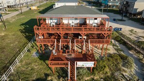 Una estructura de madera de varios niveles con asientos al aire libre y una escalera que conduce a una terraza.