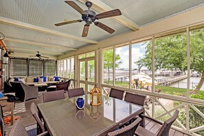 Une terrasse couverte avec une table, des chaises et un canapé.