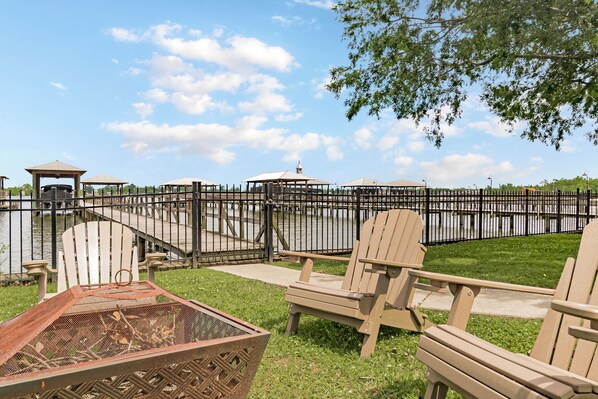 A park with outdoor seating, a grill, and a view of a body of water.