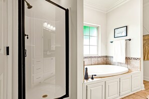 Une salle de bain avec une douche, une baignoire, un lavabo et une fenĂȘtre.