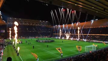 A stadium with a football field, surrounded by spectators.