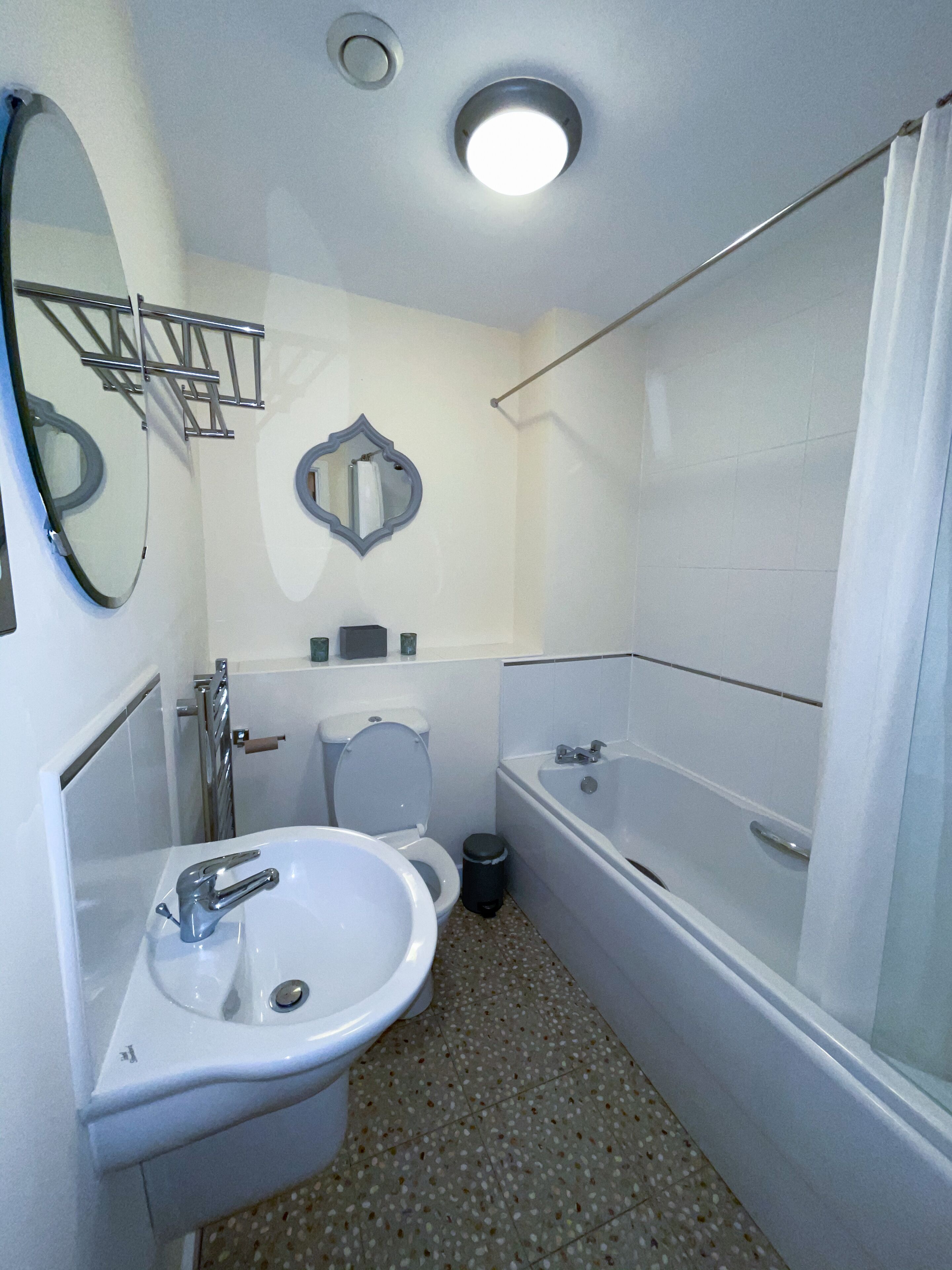 Een kleine badkamer met een wastafel, toilet en bad.