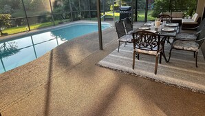 Zona exterior coberta amb piscina, mobles de terrassa i una barbacoa.