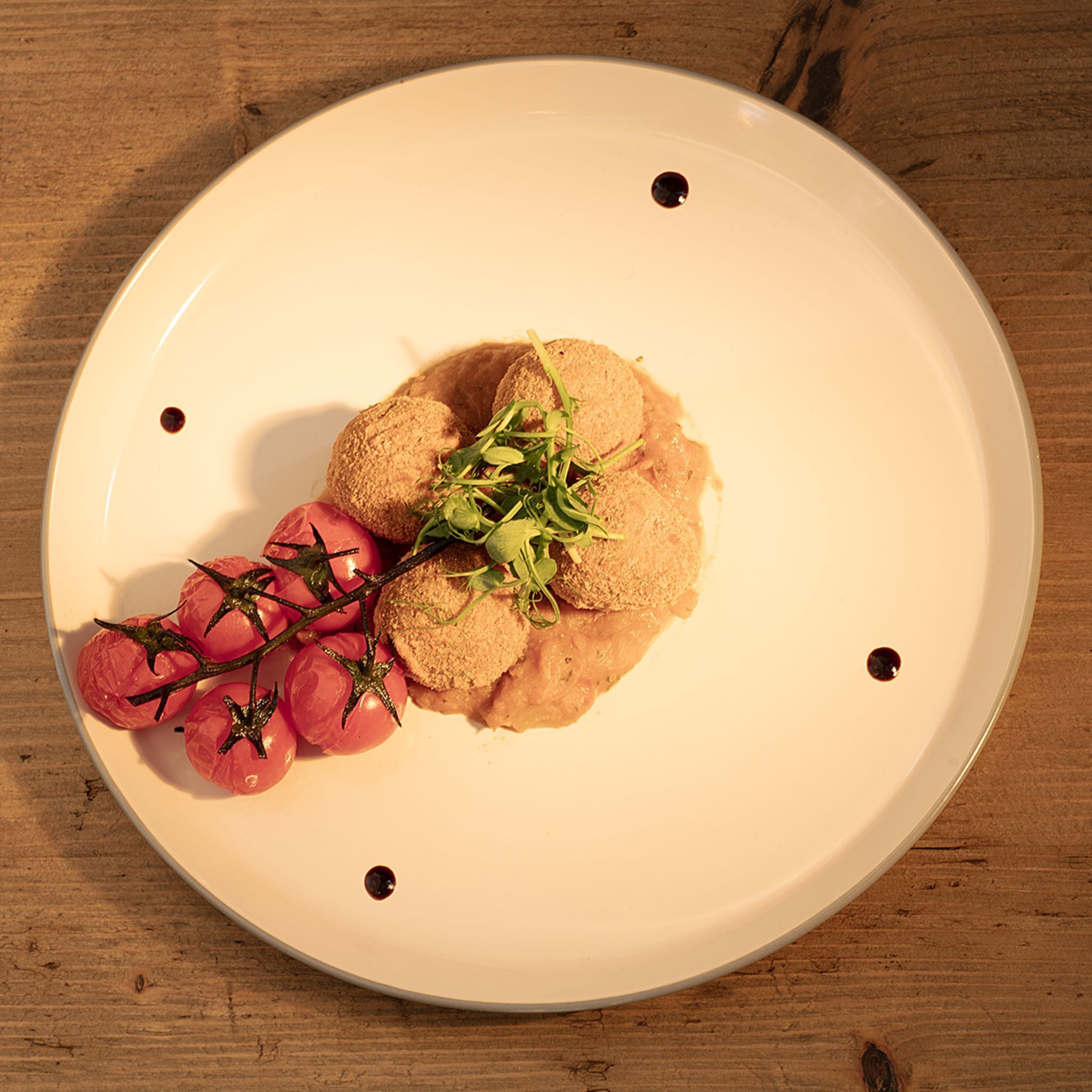 A white plate with food on a wooden table.