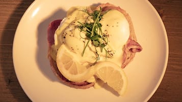 A plate with a sandwich, a slice of lemon, and a poached egg on toast.