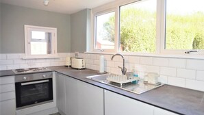 Eine moderne Küche mit Einbauofen, Spüle und einem Wasserhahn sowie einem Fenster über der Spüle.