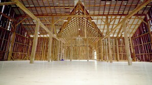 A large, open interior space with a high ceiling and wooden beams.