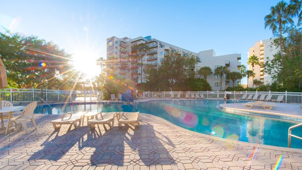 Una piscina con lettini da relax e solarium piastrellato.