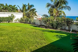 A well-maintained golf course with a clear view of the ocean in the background.