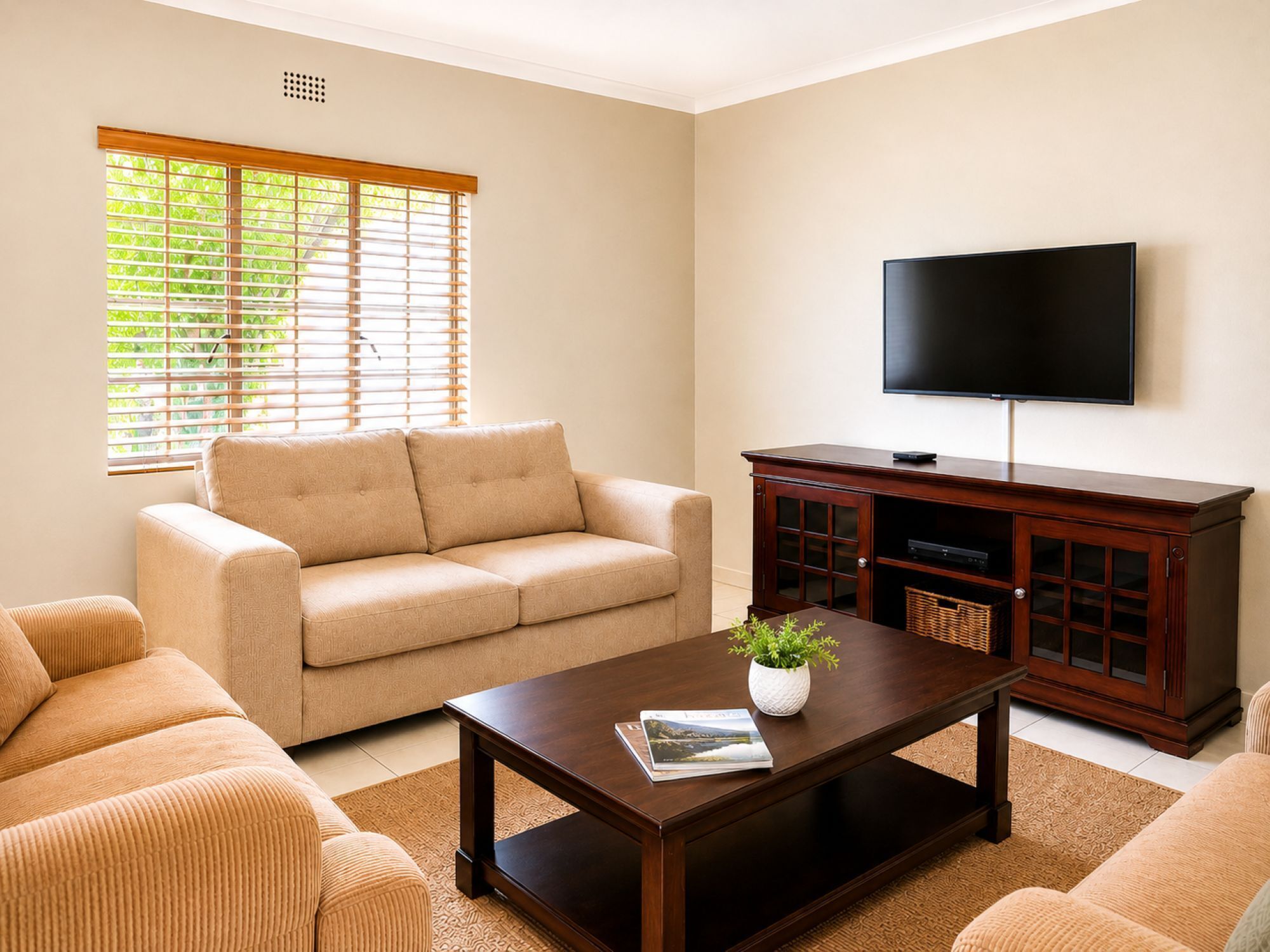 A living room with a sofa, coffee table, TV, and wooden cabinet.