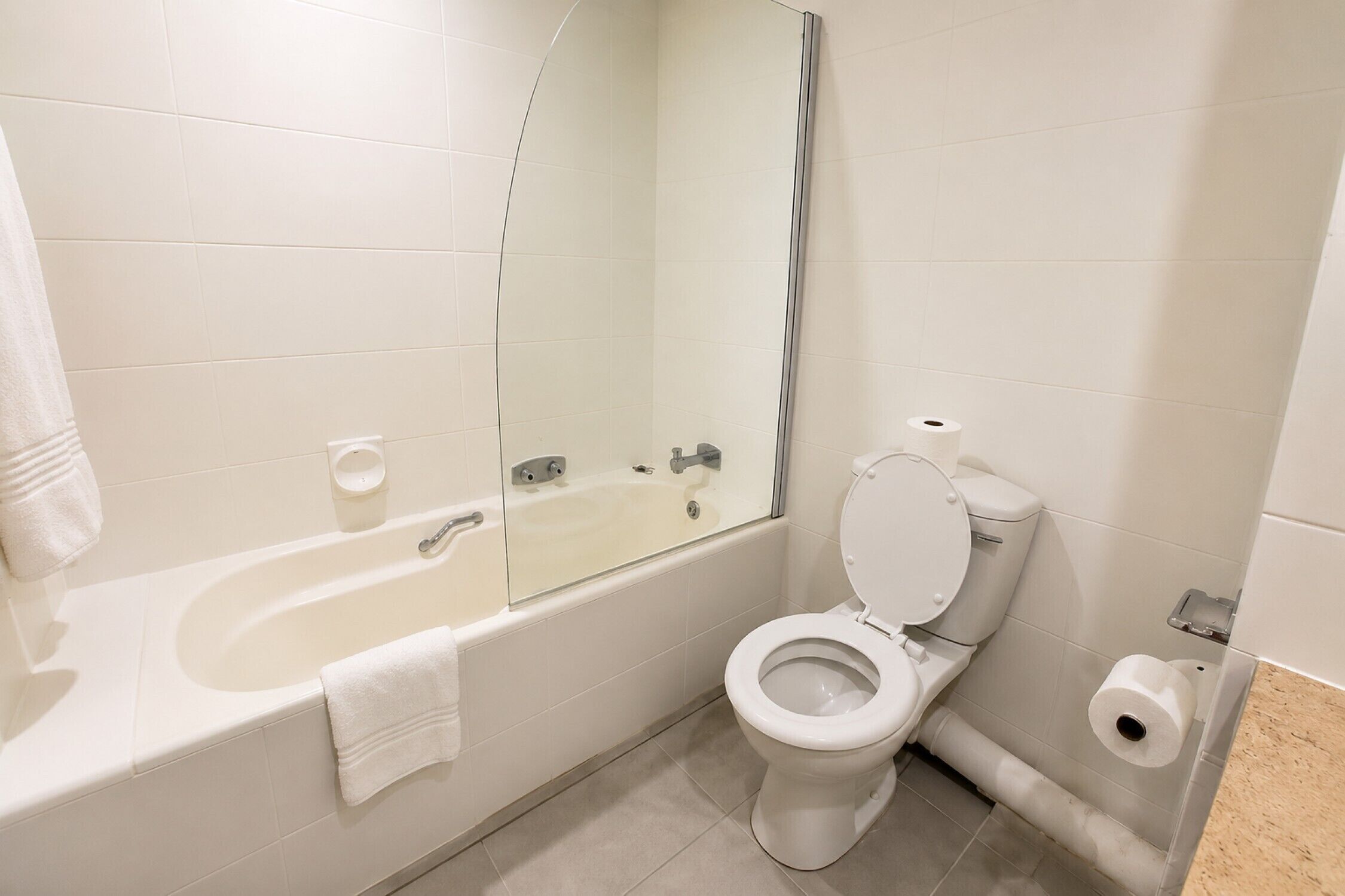 Un baño con bañera, inodoro y espejo.