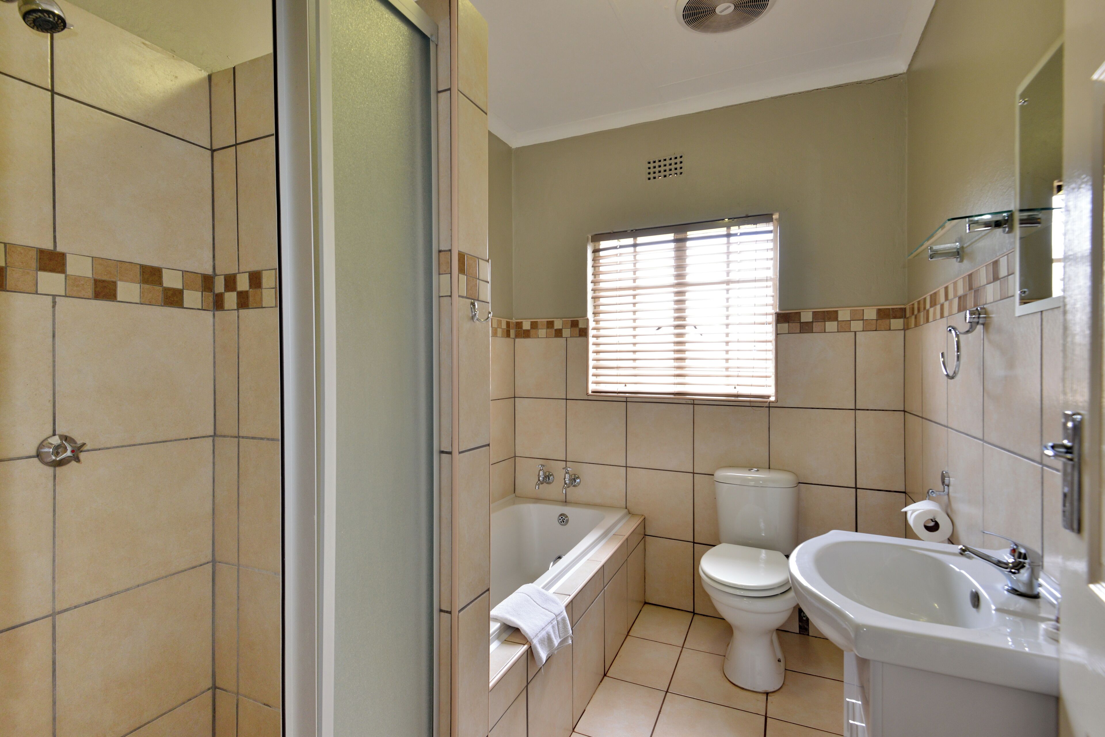 A bathroom with a bathtub, toilet, and sink.