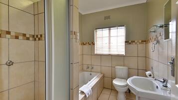 A bathroom with a bathtub, toilet, and sink.