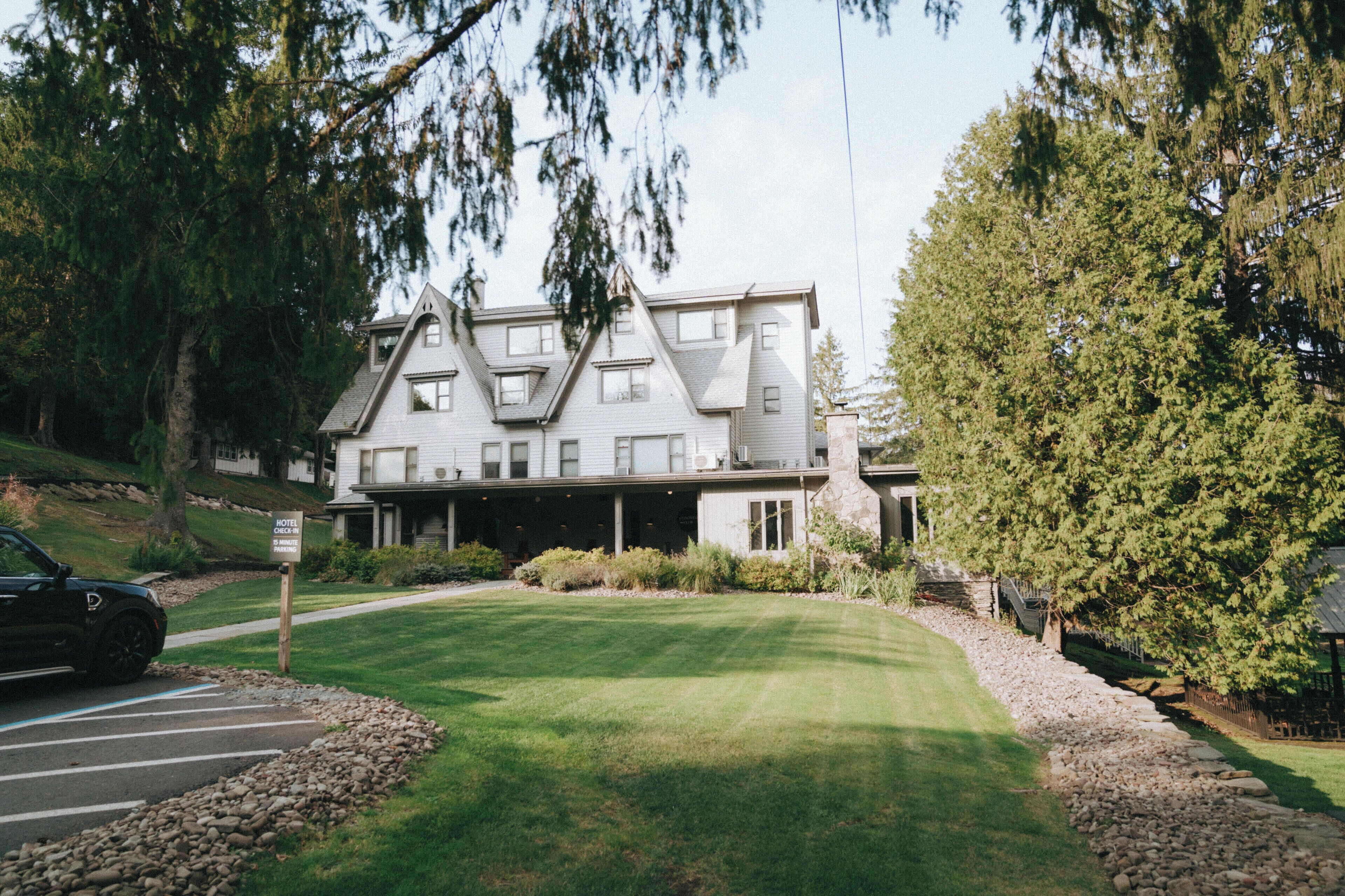 A large, two-story building with a symmetrical facade, multiple windows, and a stone foundation.