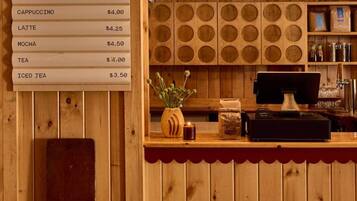 Una barra de madera con un menú que muestra los precios del café y del té.