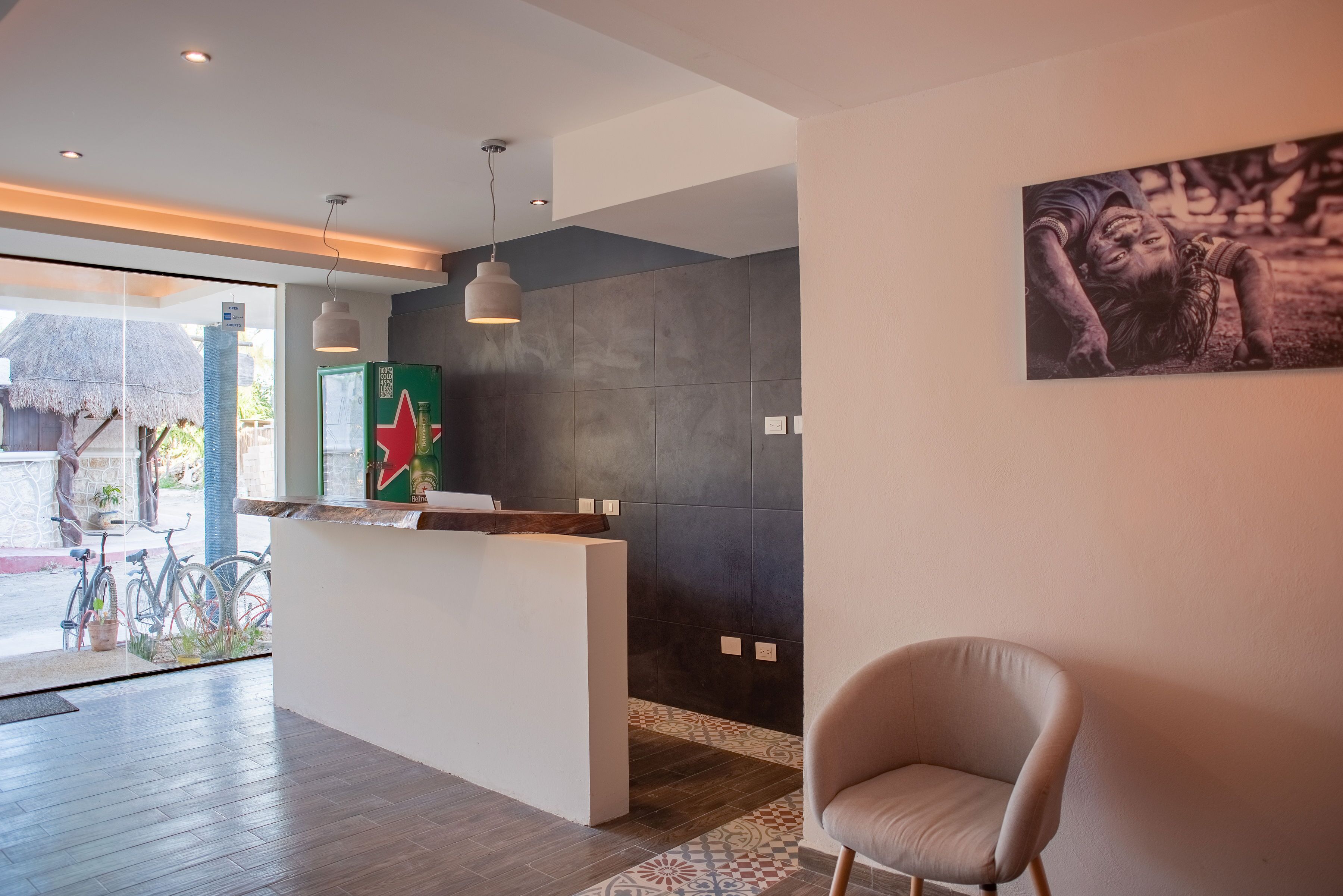 Un espace d’accueil au design moderne, comprenant un comptoir de réception, un fauteuil et un grand tableau accroché au mur.
