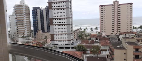 A coastal residential area with high-rise buildings, a view of the ocean, and palm trees.