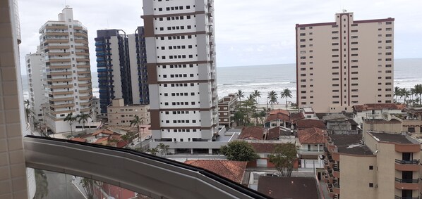 A coastal residential area with high-rise buildings, a view of the ocean, and palm trees.