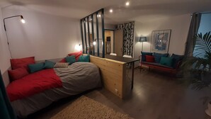 Un dormitorio moderno con cama, escritorio y sofá.