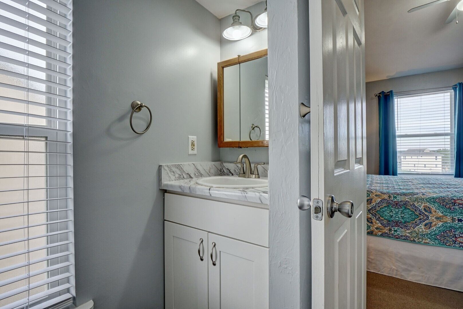Une salle de bain équipée d’un lavabo, d’un miroir et d’un porte-serviettes.