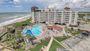 A beachfront hotel with a large pool, multiple balconies, and a view of the ocean. - Top floor, oceanfront views! (North Topsail Beach)